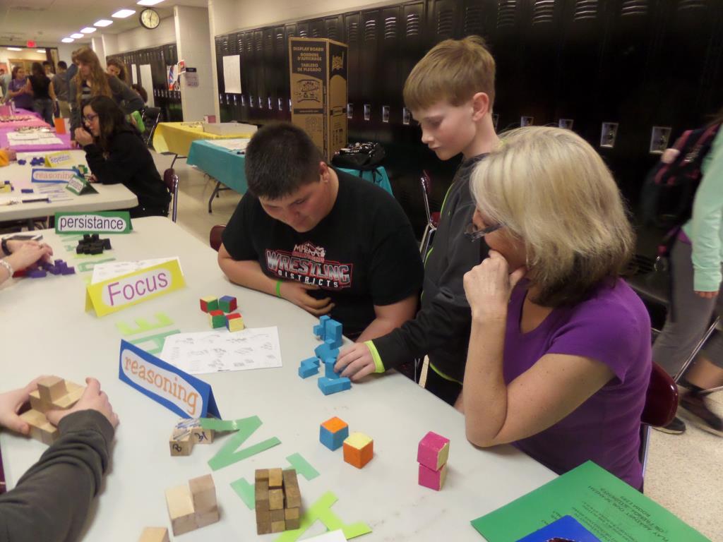 High School teacher Ms. VanWylen solving math puzzles with students of all ages.